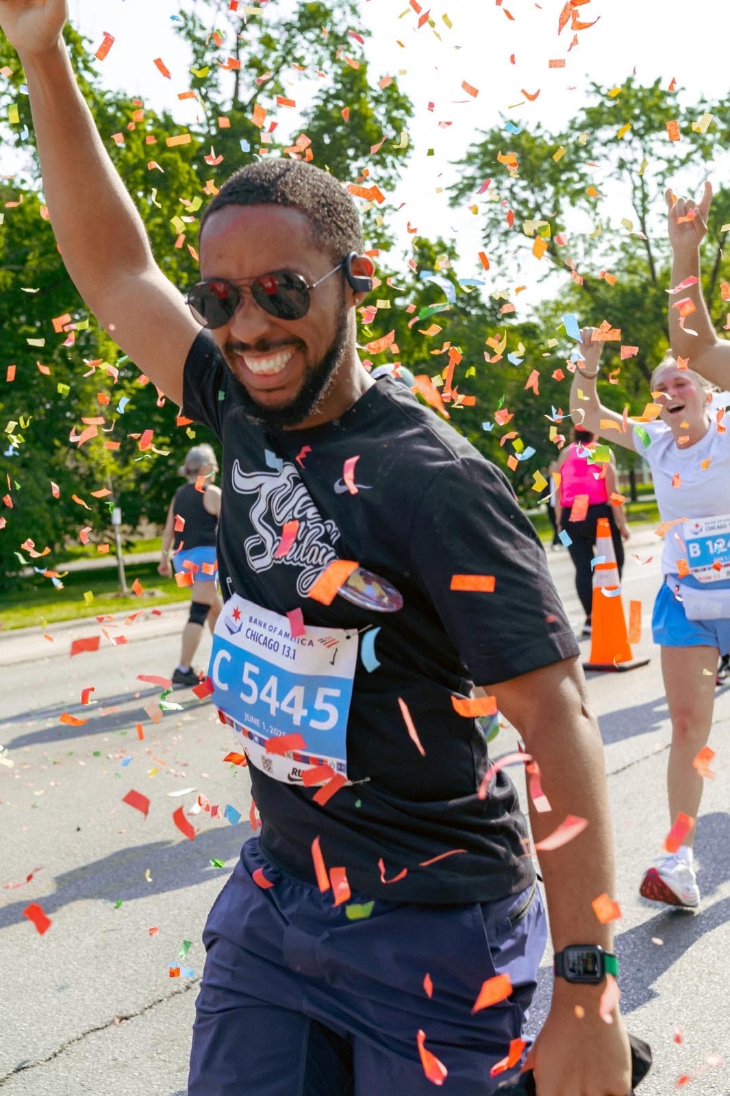 Runner with an arm raised under a burst of confetti