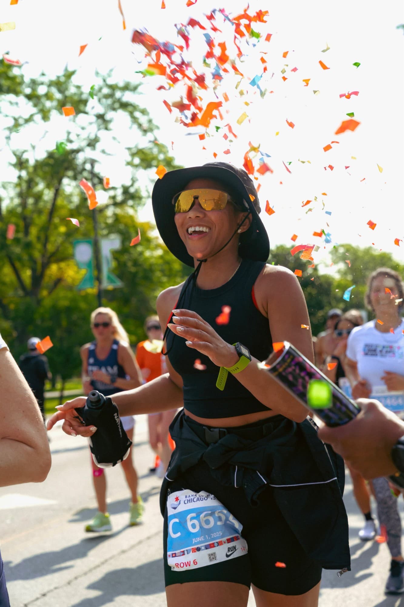 Runner in a bucket hat smiling through a confetti shower