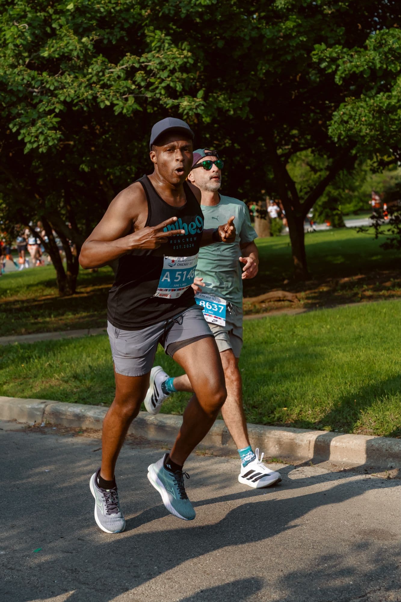 Crew member in an onthe9 Run Crew tank flashing a 9 at the Chicago 13.1